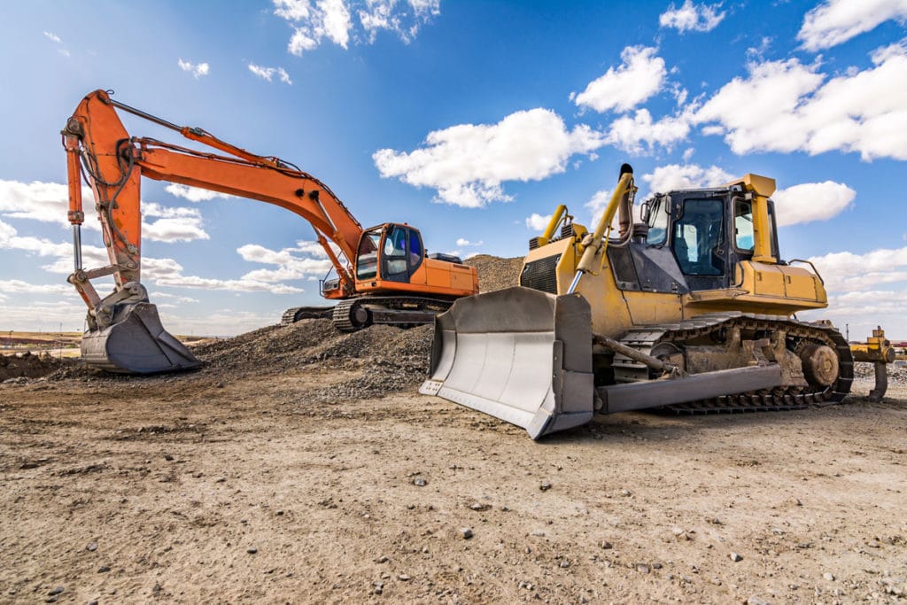 Construction equipment at job site, showcasing applications for Fisher Barton's durable wear components and cutting solutions.